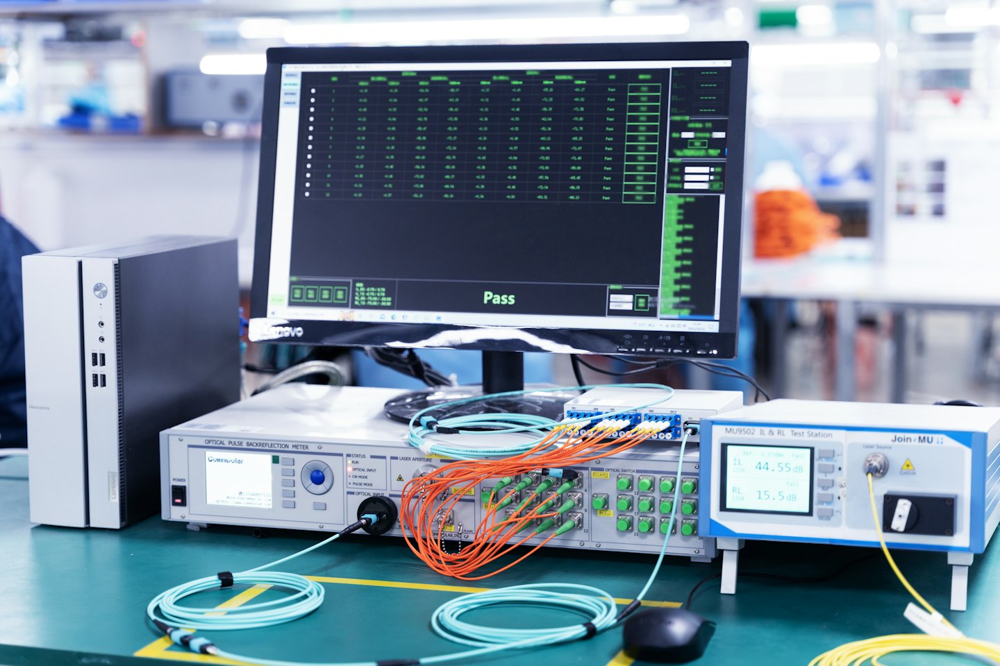 Fiber optic testing equipment with cables and pass results on screen.